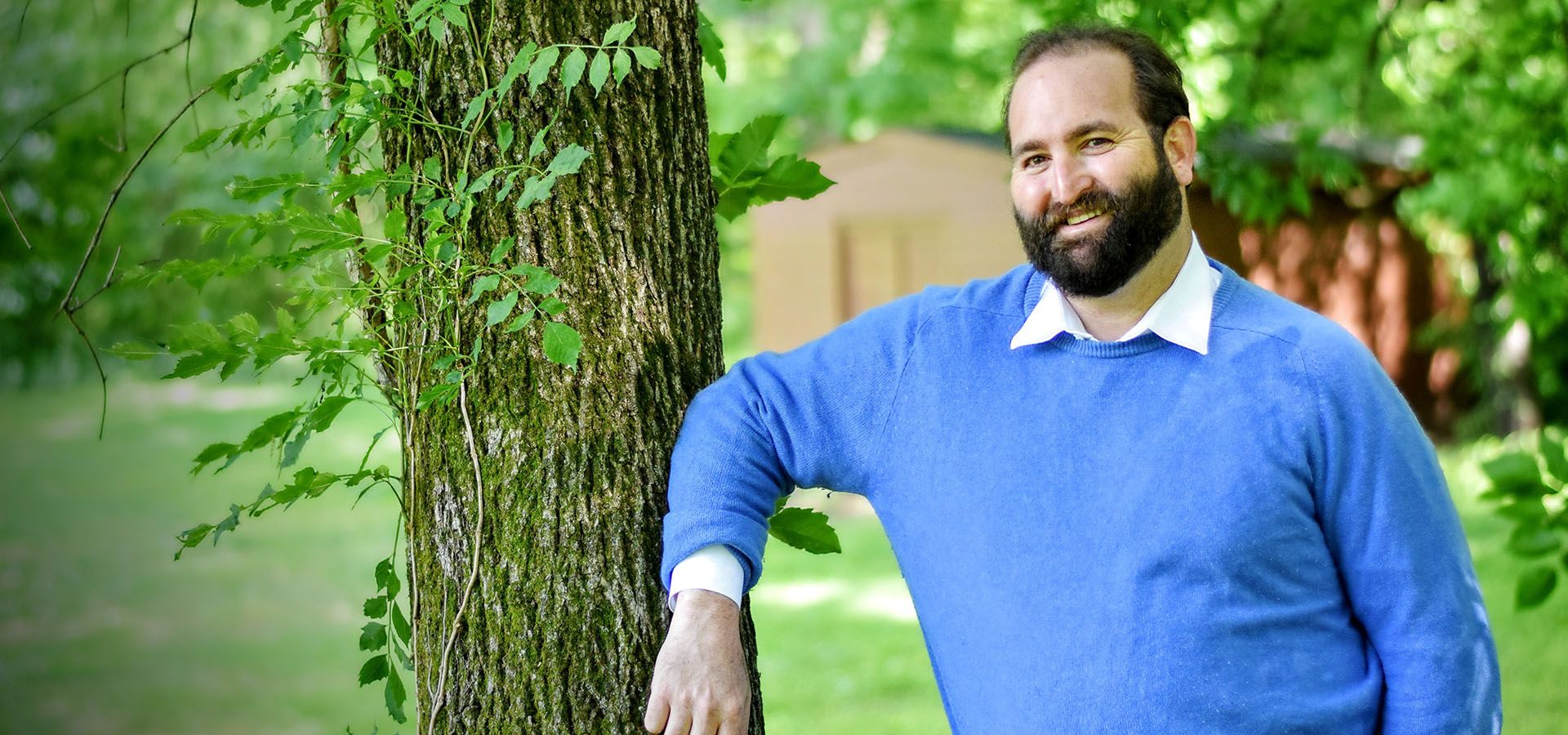 Dr. Dan Goldstein leaning on tree