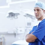 Male doctor in scrubs standing in operating room