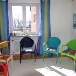 different colored chairs in a room with a window