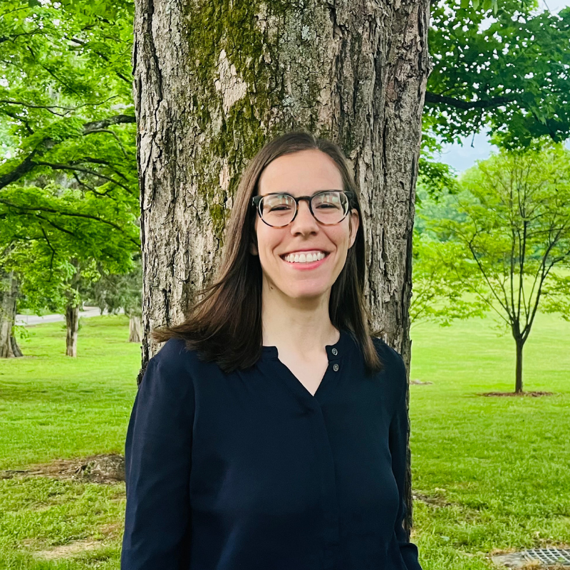 Julie Singer, Nashville therapist, smiles in front of tree in park.