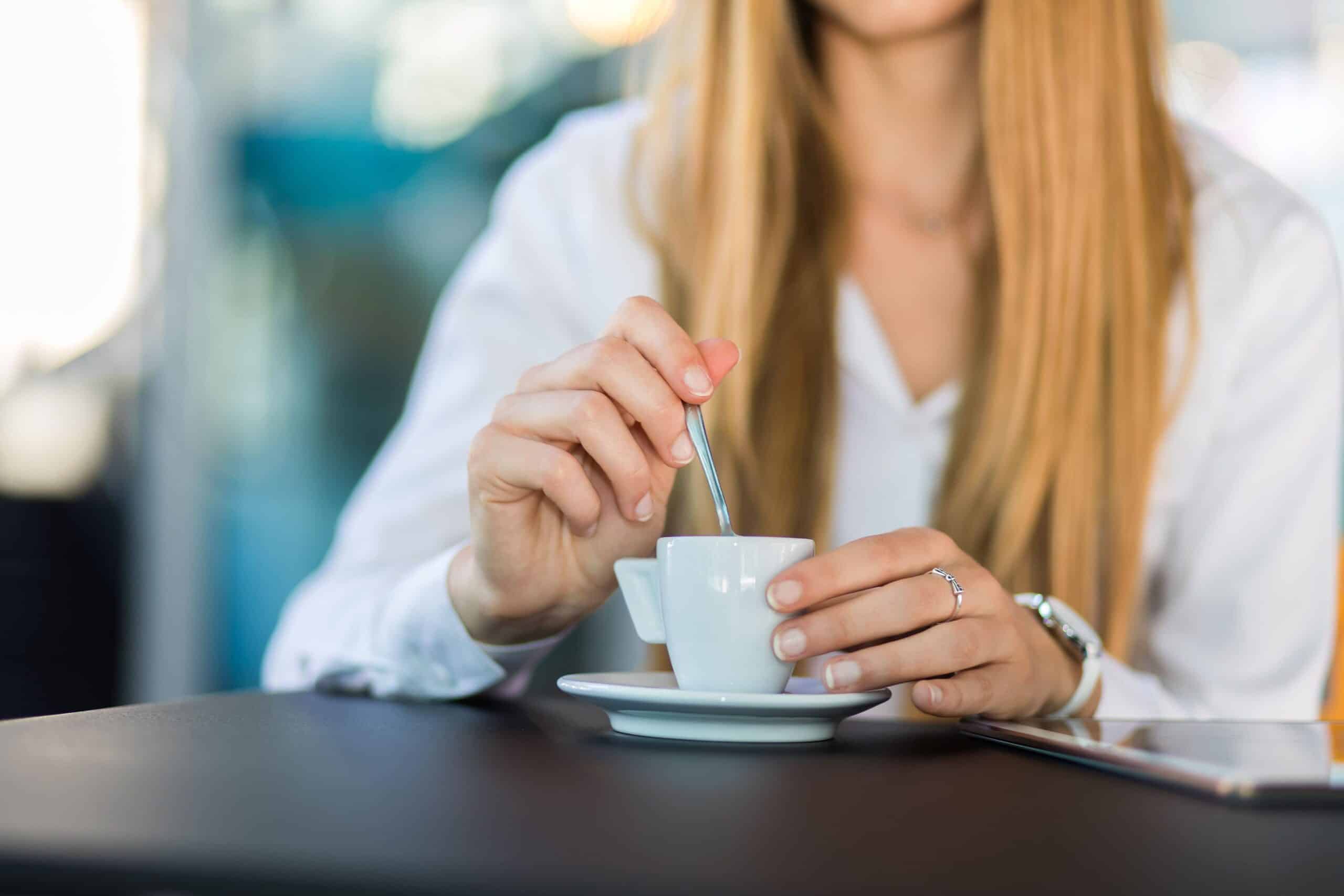 Woman at table by herself stiring coffee to represent loneliness of being a therapist